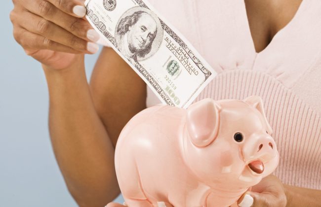 Woman saving money in piggy bank